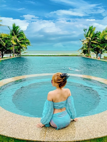 Una piscina al aire libre, sillones reclinables de piscina