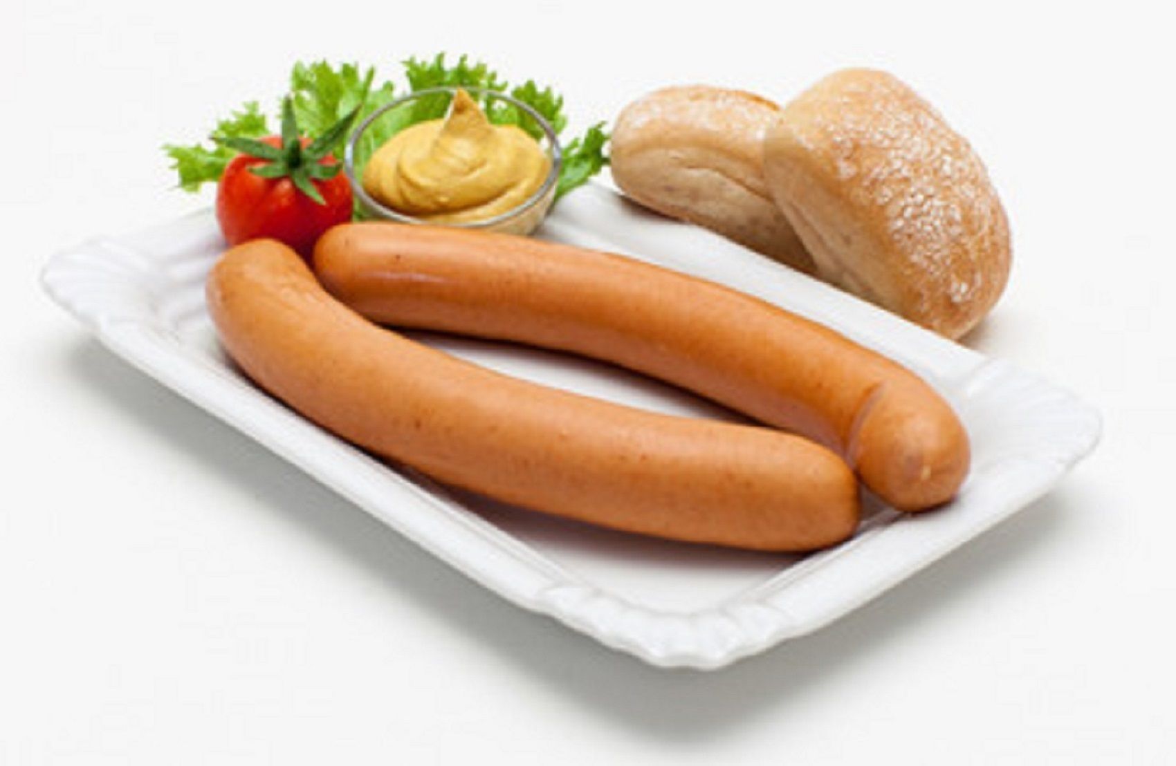 Ein Teller mit zwei Bratwurst, eine kleine Schale Senf, eine Scheibe Brot und eine Tomate.