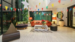 Un vestíbulo moderno con un sofá, una mesa de centro e iluminación decorativa.