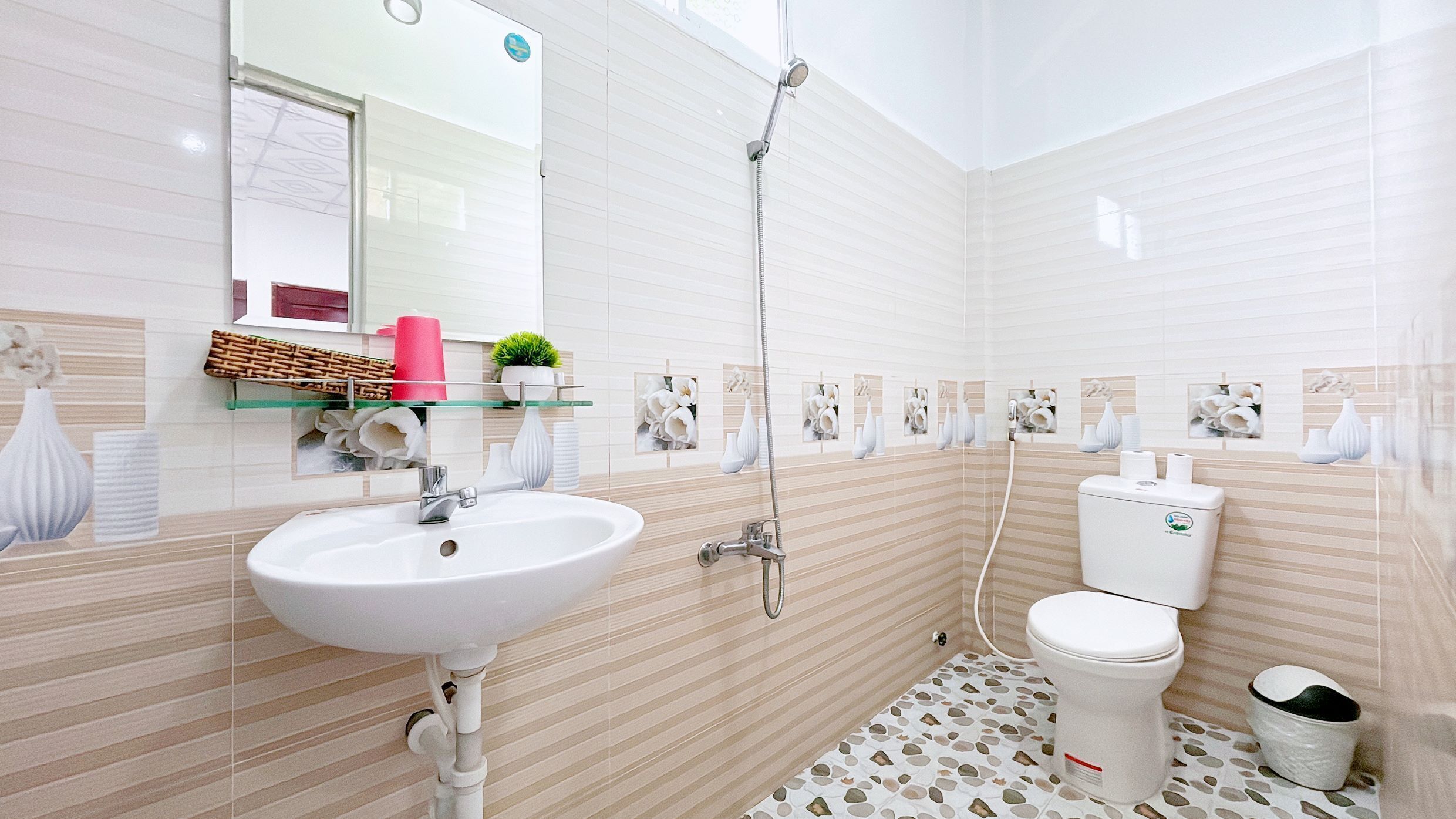 Un baño moderno con lavamanos, inodoro y ducha blancos.