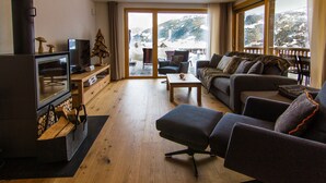 Una sala de estar acogedora con chimenea, un sofá, una mesita de centro y un televisor.
