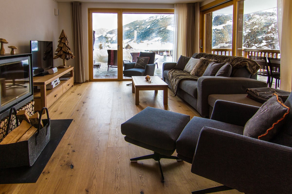 A cozy living room with a fireplace, a sofa, a coffee table, and a television.