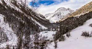 A snow-covered mountain landscape with a cabin and forested area. - Chalet Les Rahâs Grimentz (Anniviers)