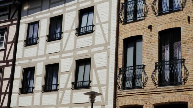 Un edificio tradicional con entramado de madera, con varias ventanas y balcones.