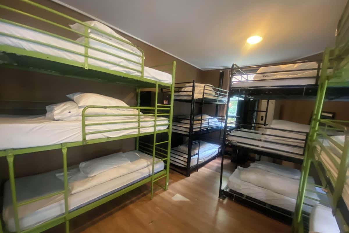 Une chambre de dortoir avec des lits superposés disposés en deux rangées.