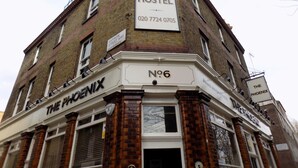 A building with a sign indicating it is a hostel. - Phoenix Hostel (London)