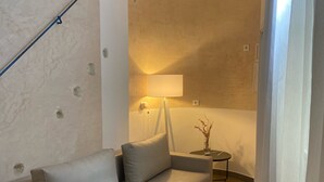 Una sala moderna con un sofá, una lámpara y una pequeña mesa.