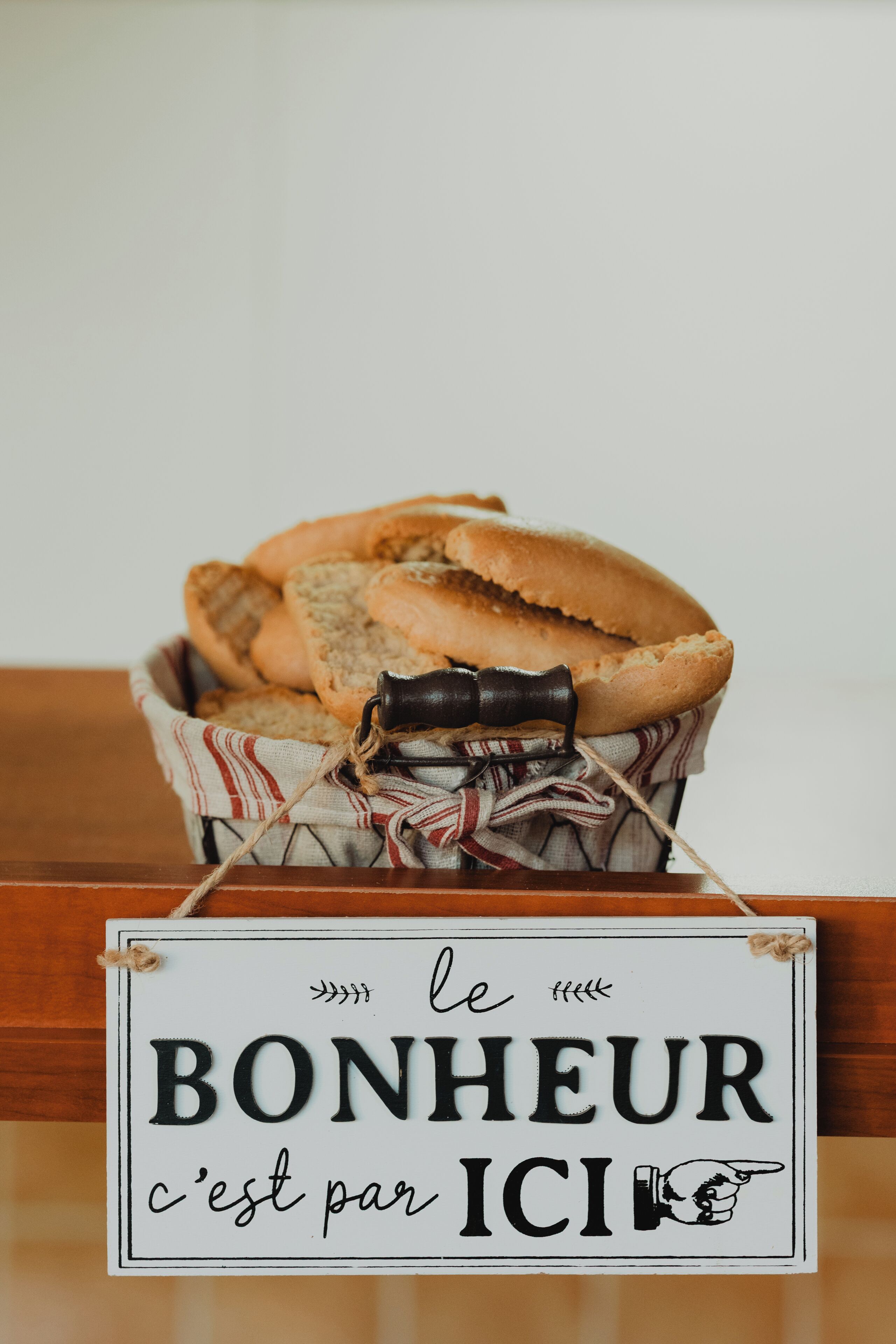Una cesta de pan con un cartel que dice 'le BONHEUR c'est par ICI'.