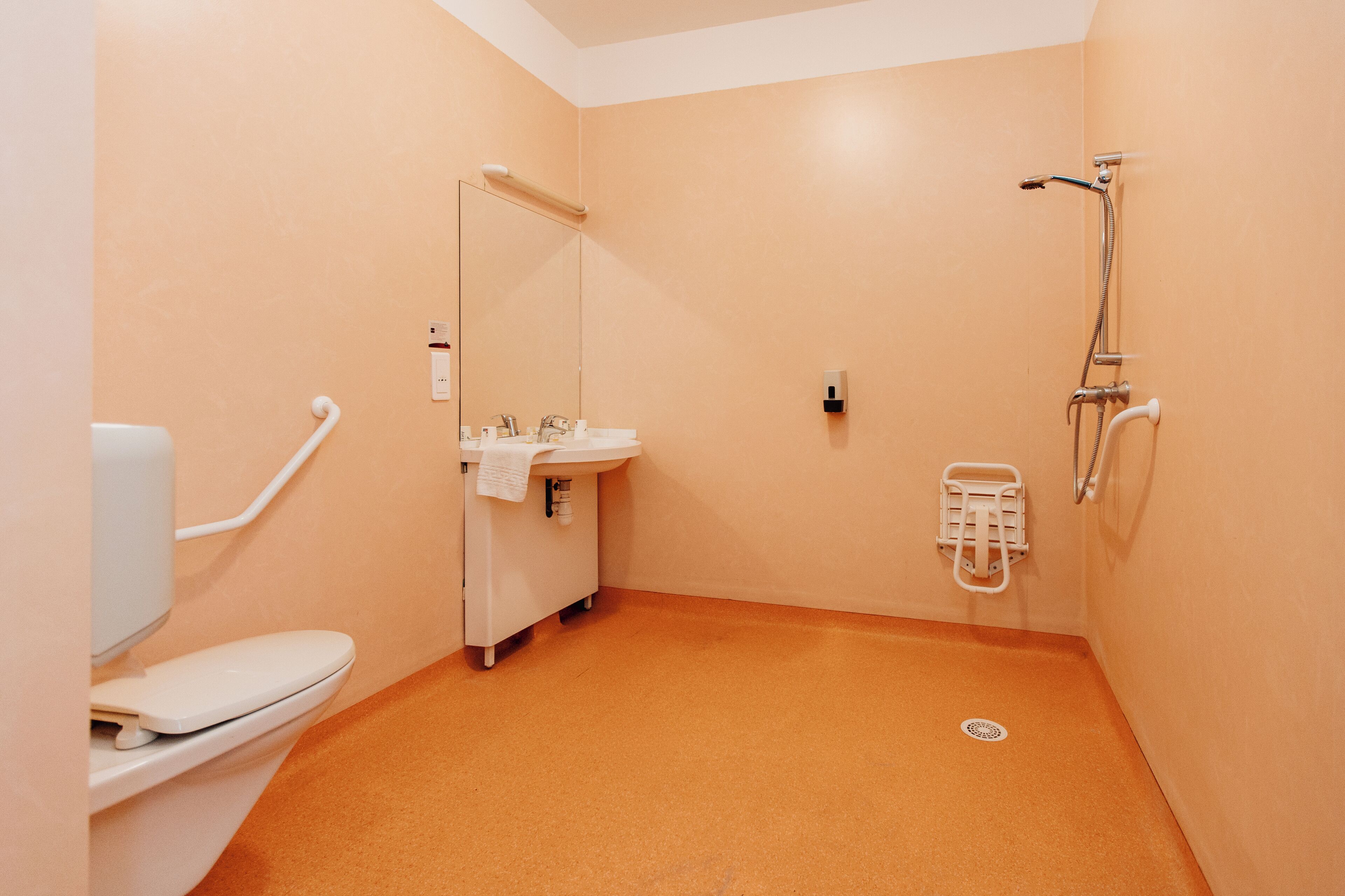 Un bagno con il water, lavandino e doccia.