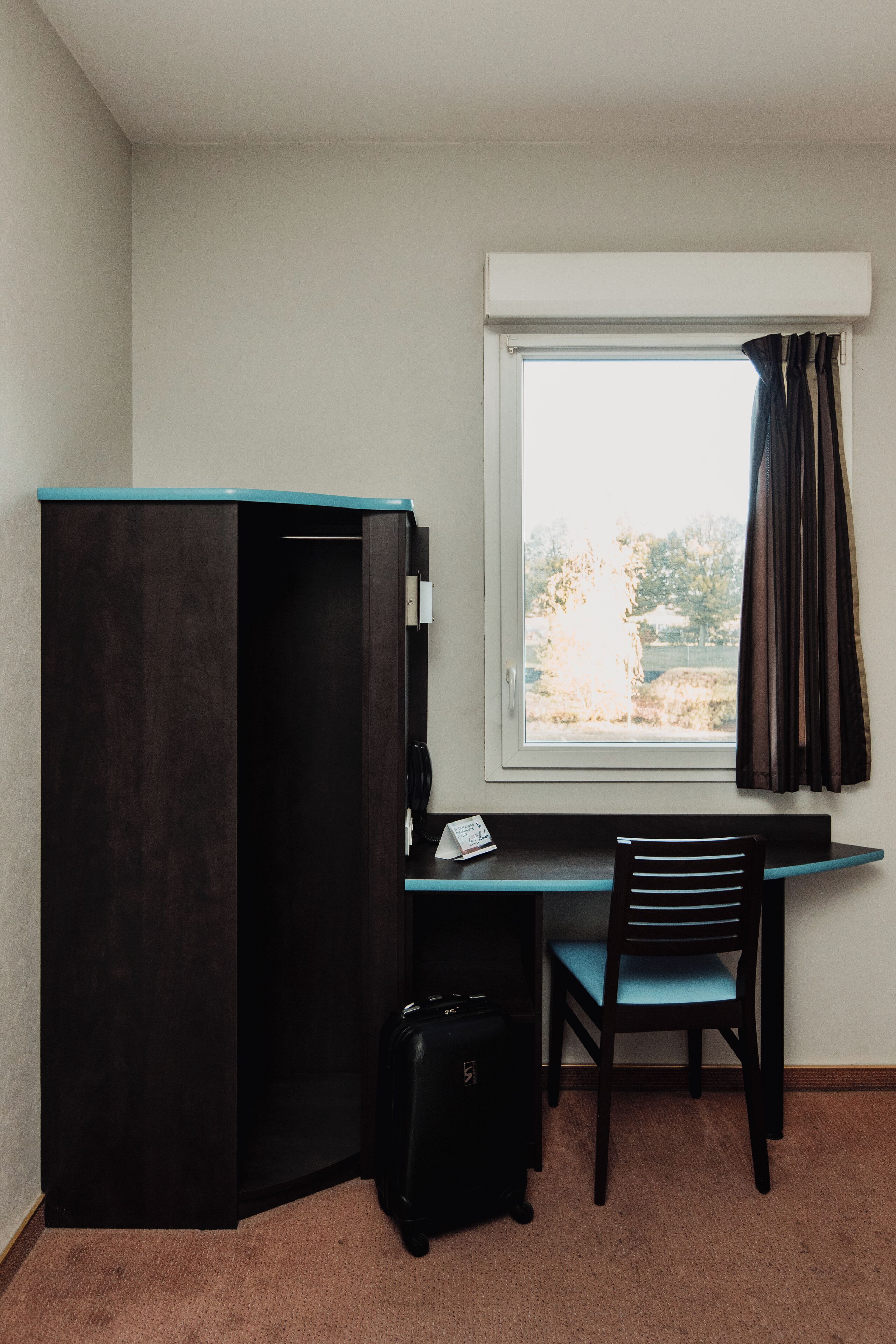 Une petite pièce comprenant un bureau, une chaise et une armoire.