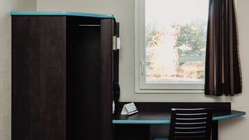 Une petite pièce comprenant un bureau, une chaise et une armoire.
