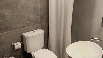 Un baño moderno con inodoro, bidé y lavamanos.