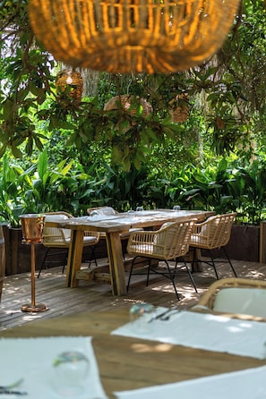 An outdoor dining area with wicker furniture and a copper table base. - Kimera Lounge Hotel (Kemer)