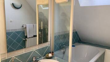 Une salle de bain avec une baignoire, un lavabo et un miroir.