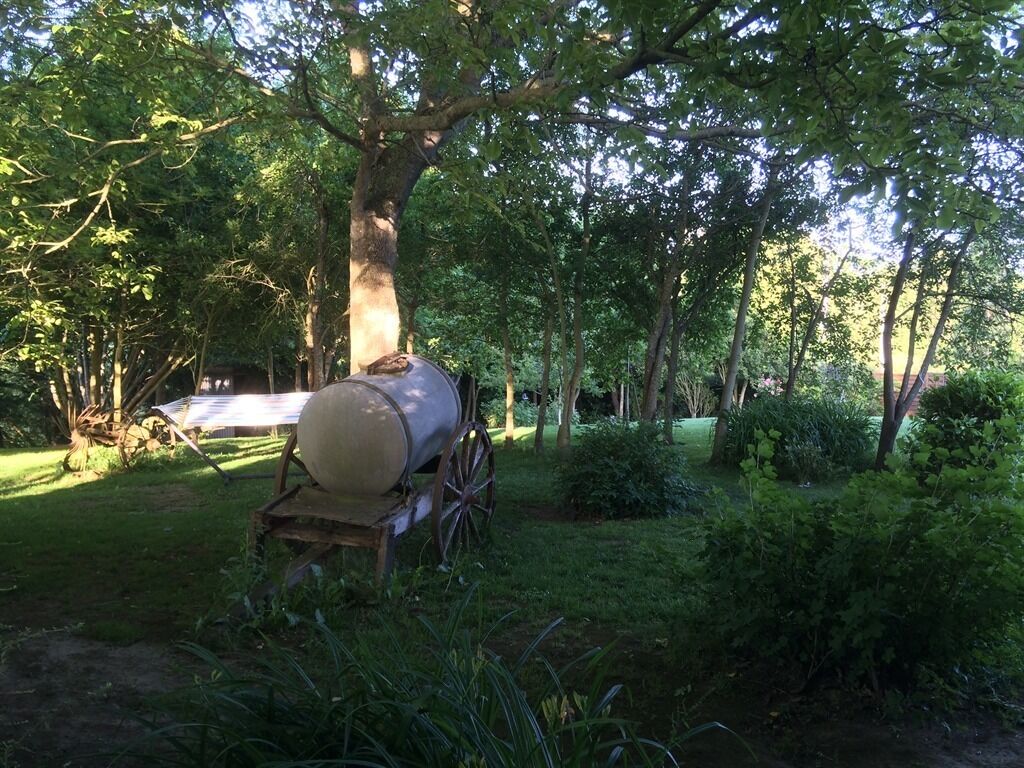 A large cylindrical object on a wooden cart in a wooded area.