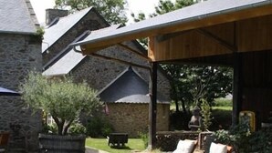 Ein Steinhaus mit überdachter Terrasse.