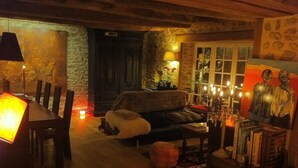 Ein gemütliches Wohnzimmer mit einem Holzesstisch, einer Couch und einem Kamin.