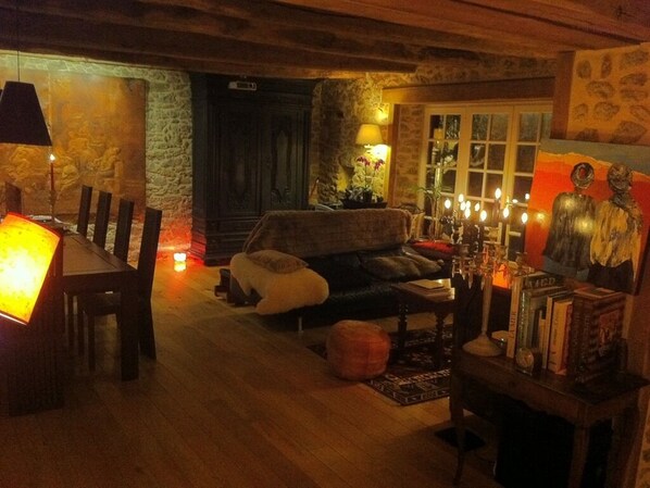 A cozy living room with a wooden dining table, a sofa, and a fireplace.