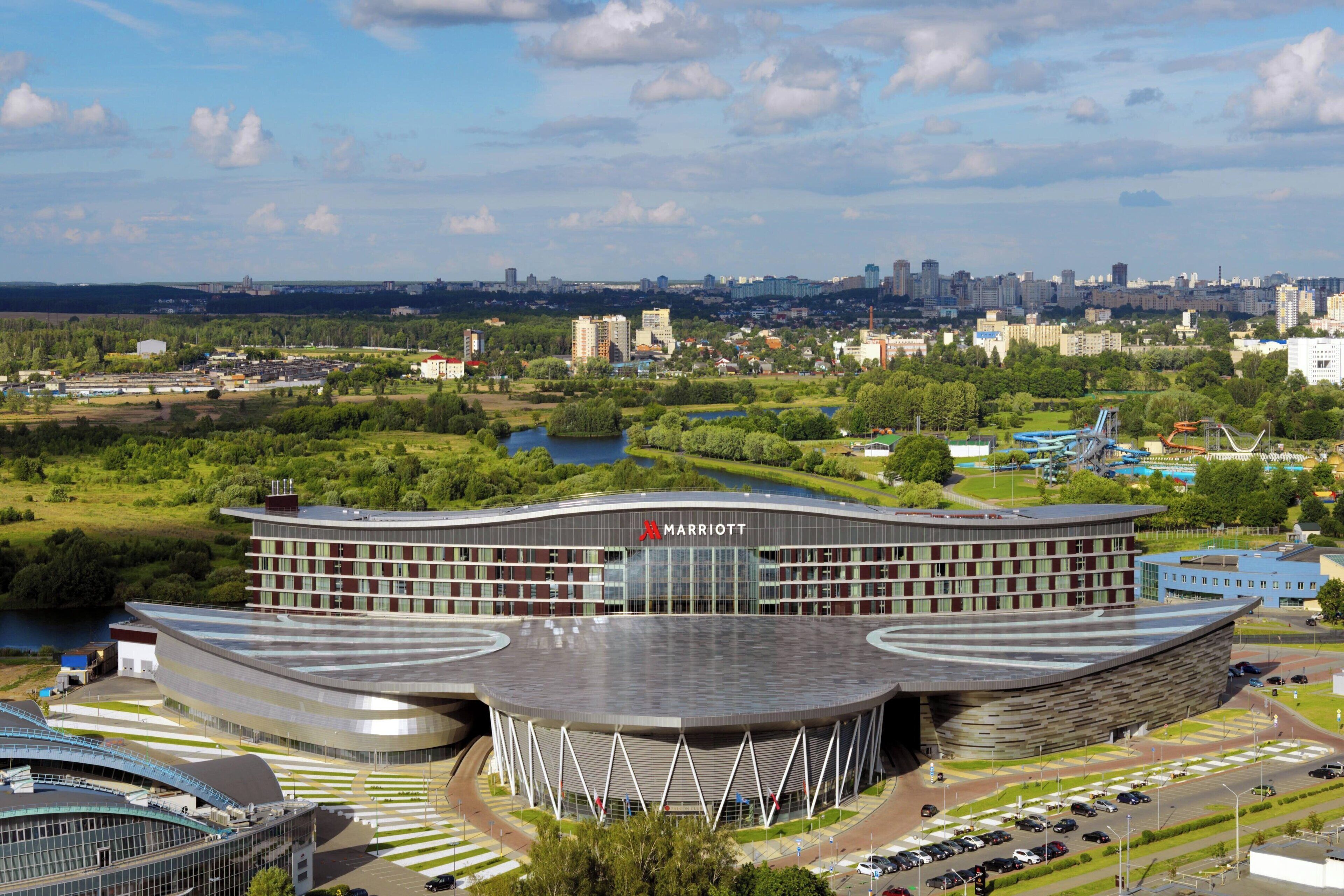 A modern hotel with a distinctive curved roof and a Marriott logo.