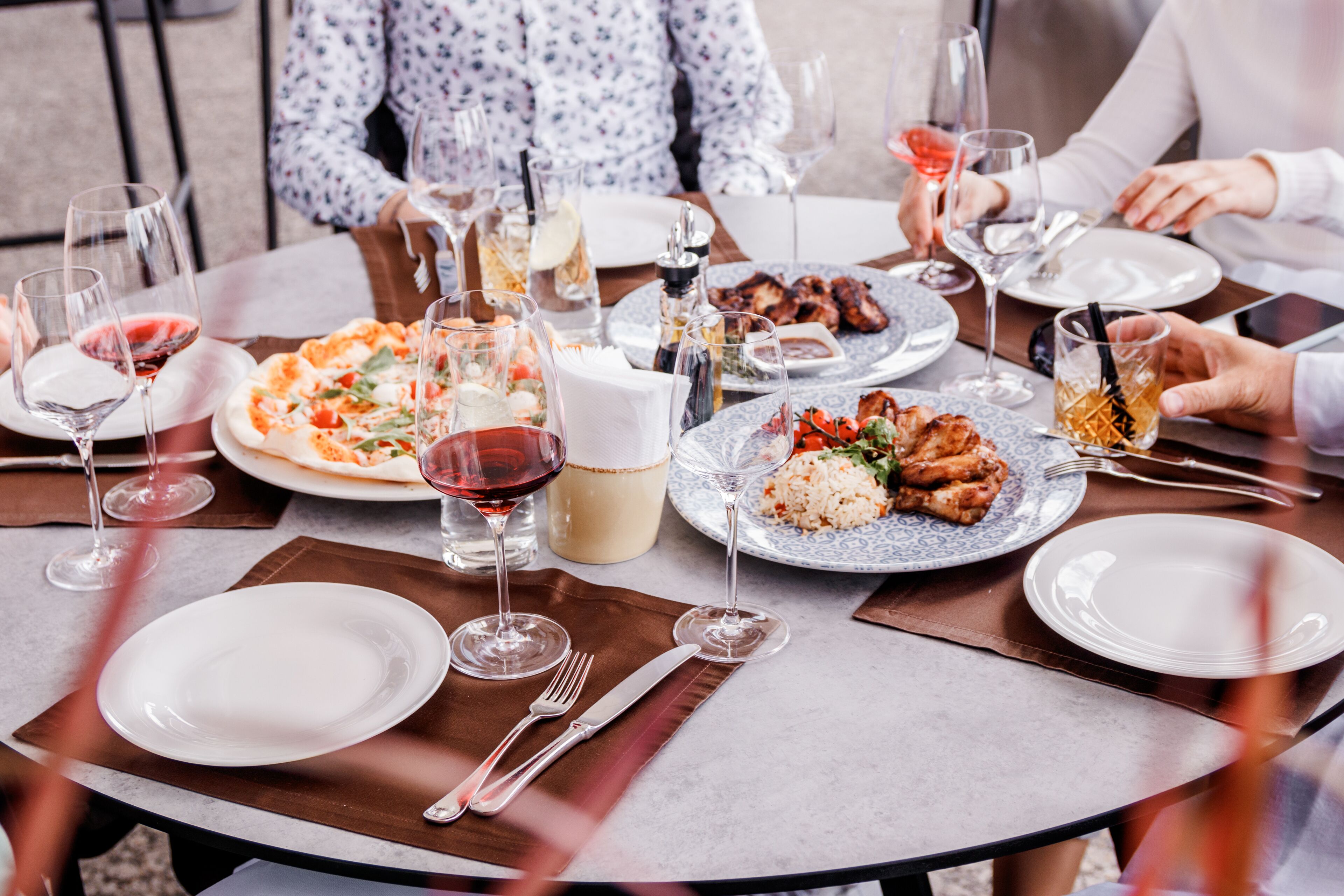 A dining table set with various dishes, wine glasses, and cutlery.