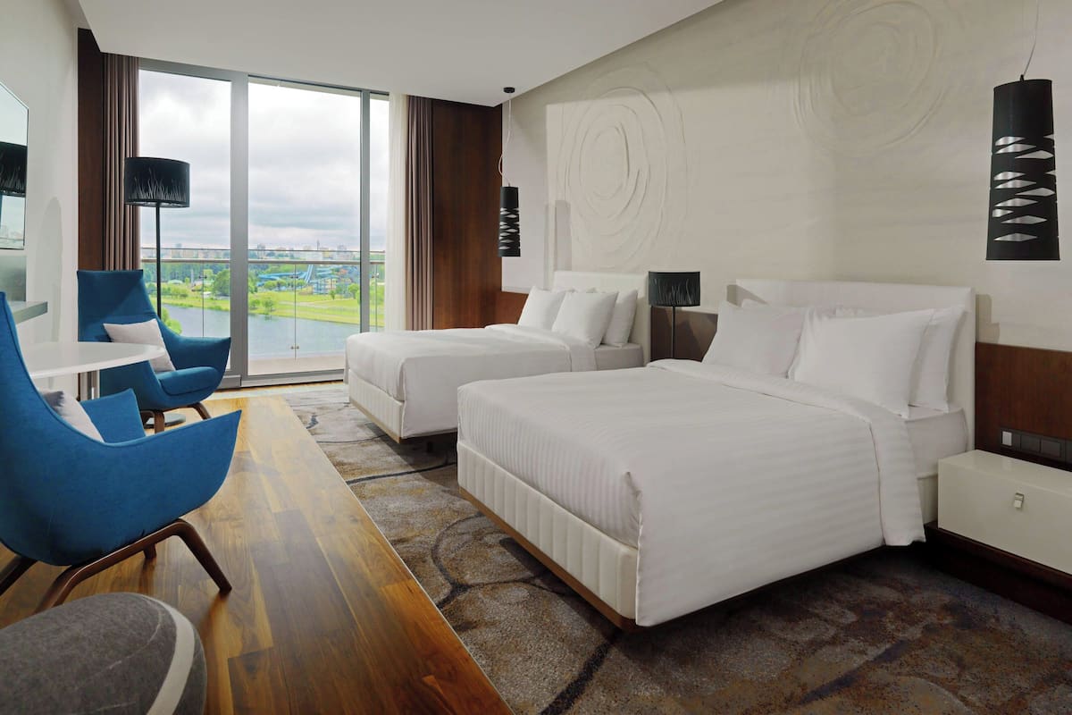 Une chambre d’hôtel avec deux lits, un bureau et une chaise.