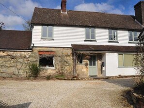 A two-story white house with a stone foundation, a chimney, and a front door. - Little Tidebrook Farm (Wadhurst)