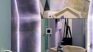 A bathroom with a large mirror, a modern sink, and a towel rack. - Eter Hotel (Niš)