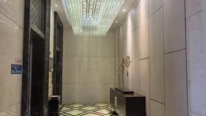 A hallway with a geometric patterned floor, a reception desk, and a modern light fixture. - Xingyue International Hotel (Xianghuli Cultural Creative Ancient Street) (Ganzhou)