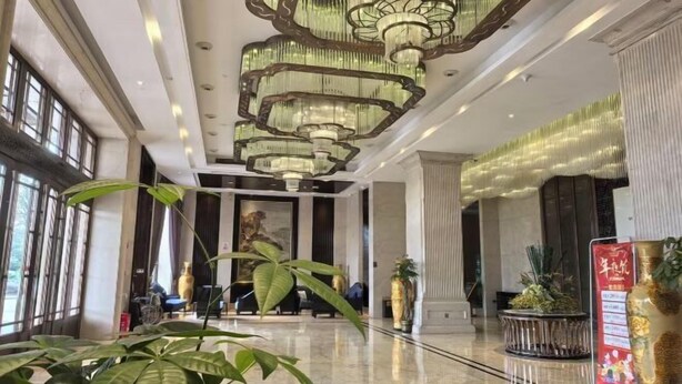 A spacious lobby with a high ceiling, large chandeliers, and potted plants. - Xingyue International Hotel (Xianghuli Cultural Creative Ancient Street) (Ganzhou)