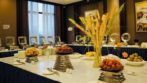 A buffet setup with various food items and a decorative vase of wheat stalks. - Xingyue International Hotel (Xianghuli Cultural Creative Ancient Street) (Ganzhou)