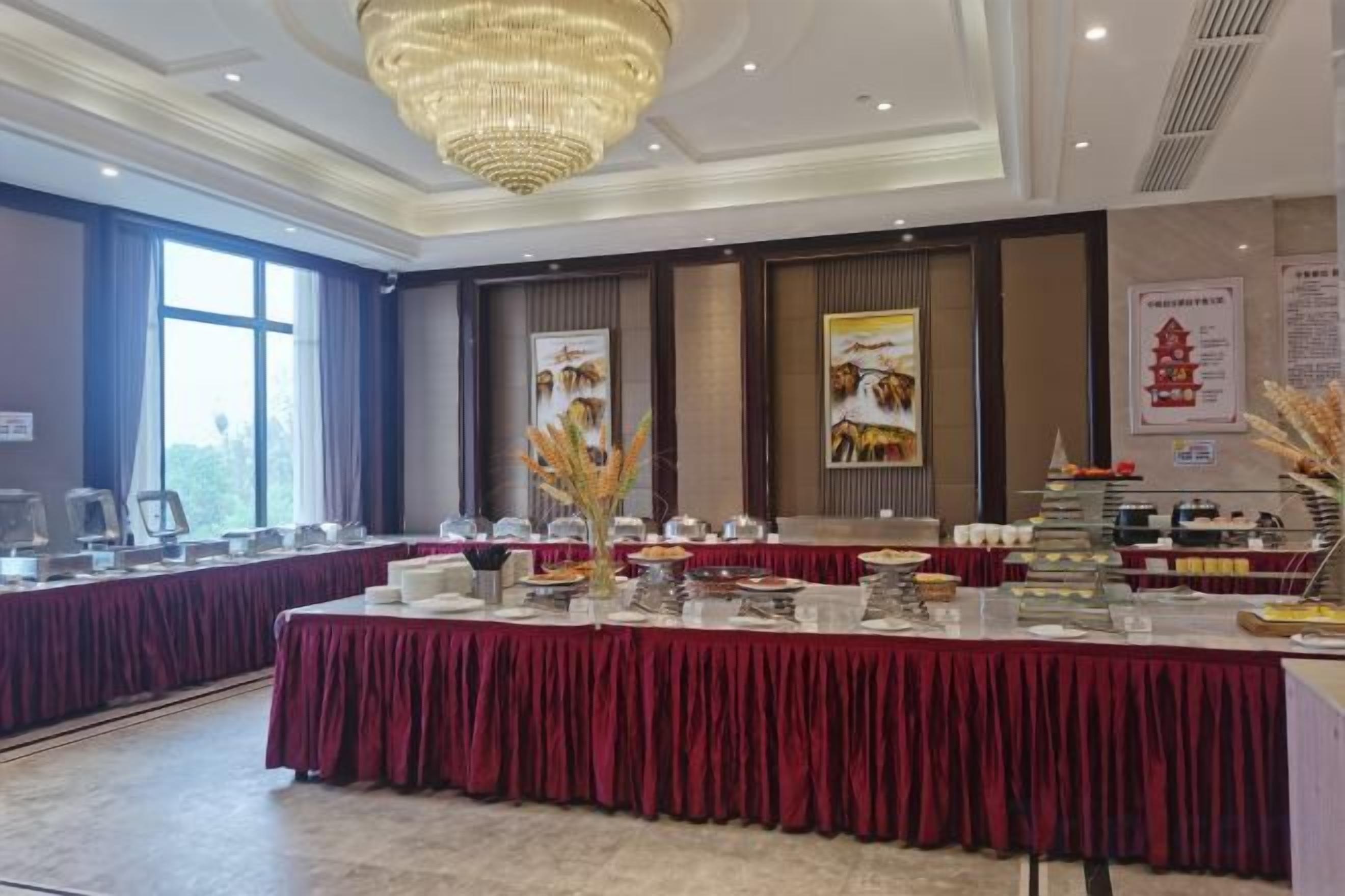 A banquet hall with a long table, chairs, and a chandelier.