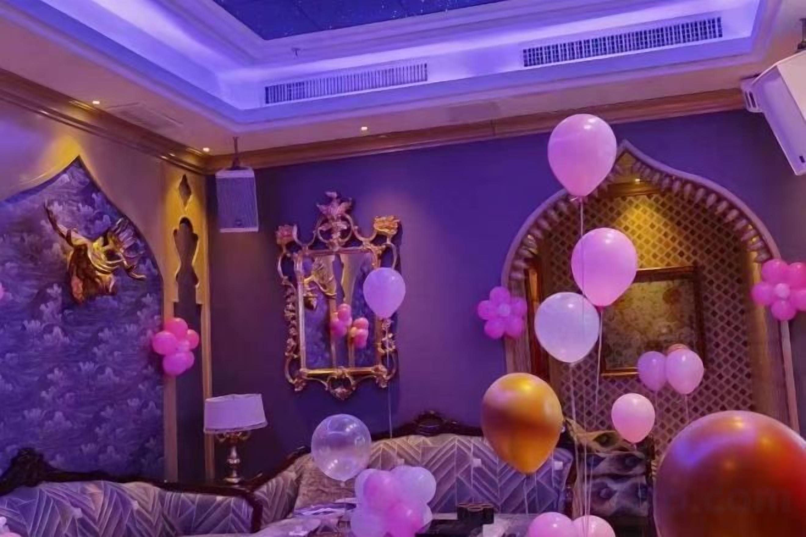 A room with a bed, a mirror, and balloons.
