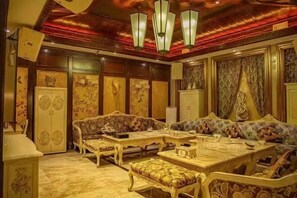 A traditional room with ornate furniture, a chandelier, and decorative wall panels.