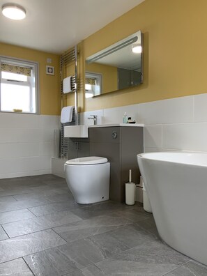 A modern bathroom with a toilet, sink, and bathtub.