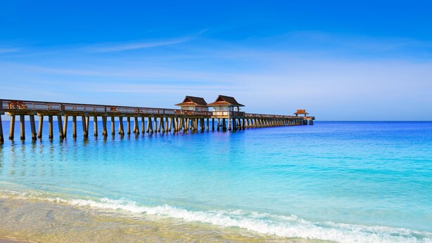 A pier extending into the ocean with overwater bungalows.