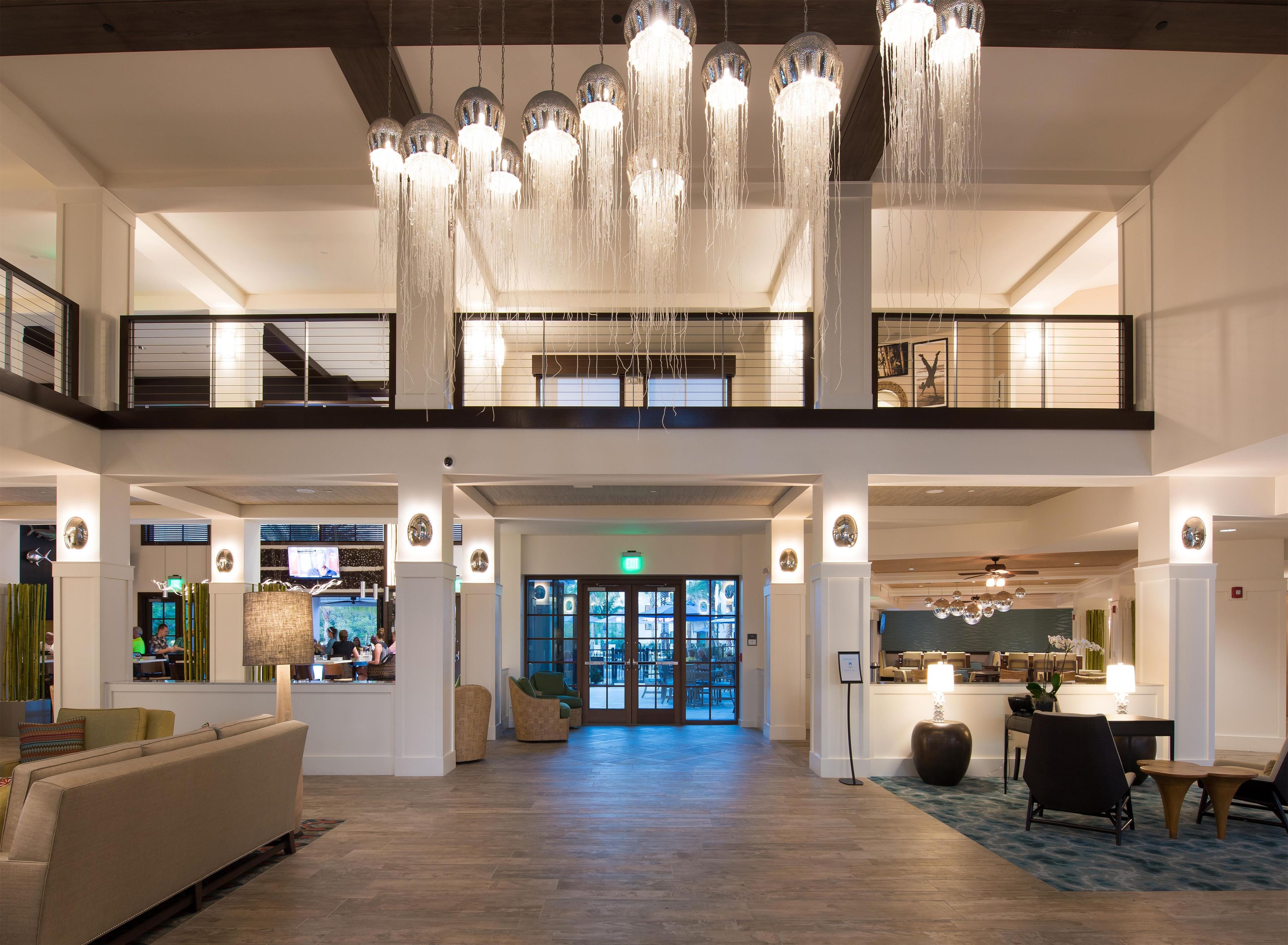 A spacious lobby with a high ceiling, multiple seating areas, and a central open space.