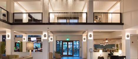 Un'ampia hall con soffitto alto, diverse zone relax e un'area centrale aperta.