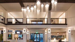 A spacious lobby with a high ceiling, multiple seating areas, and a central open space.