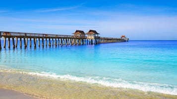 A pier extending into the ocean with overwater bungalows.