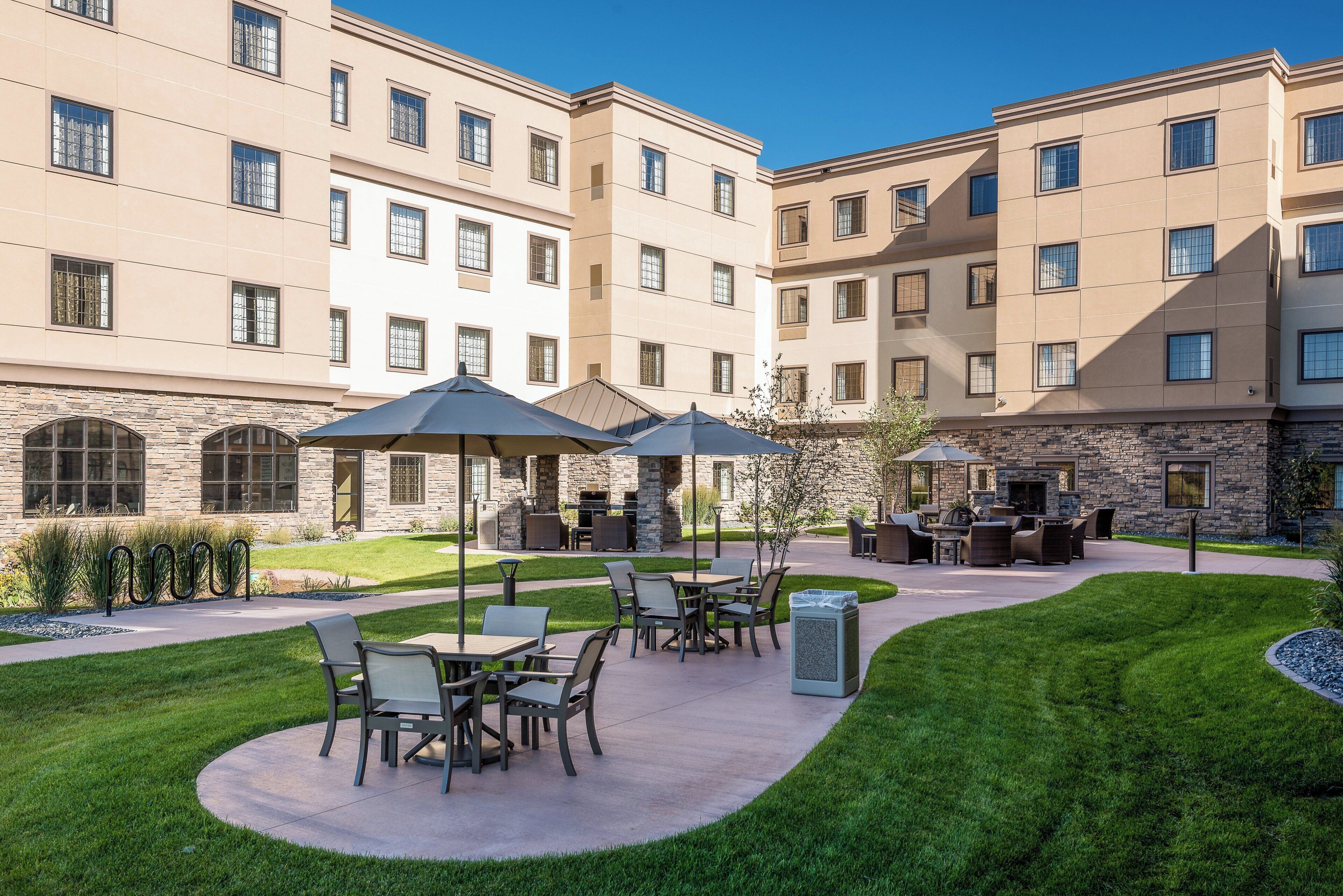 A courtyard with outdoor seating, stone walls, and a pool.