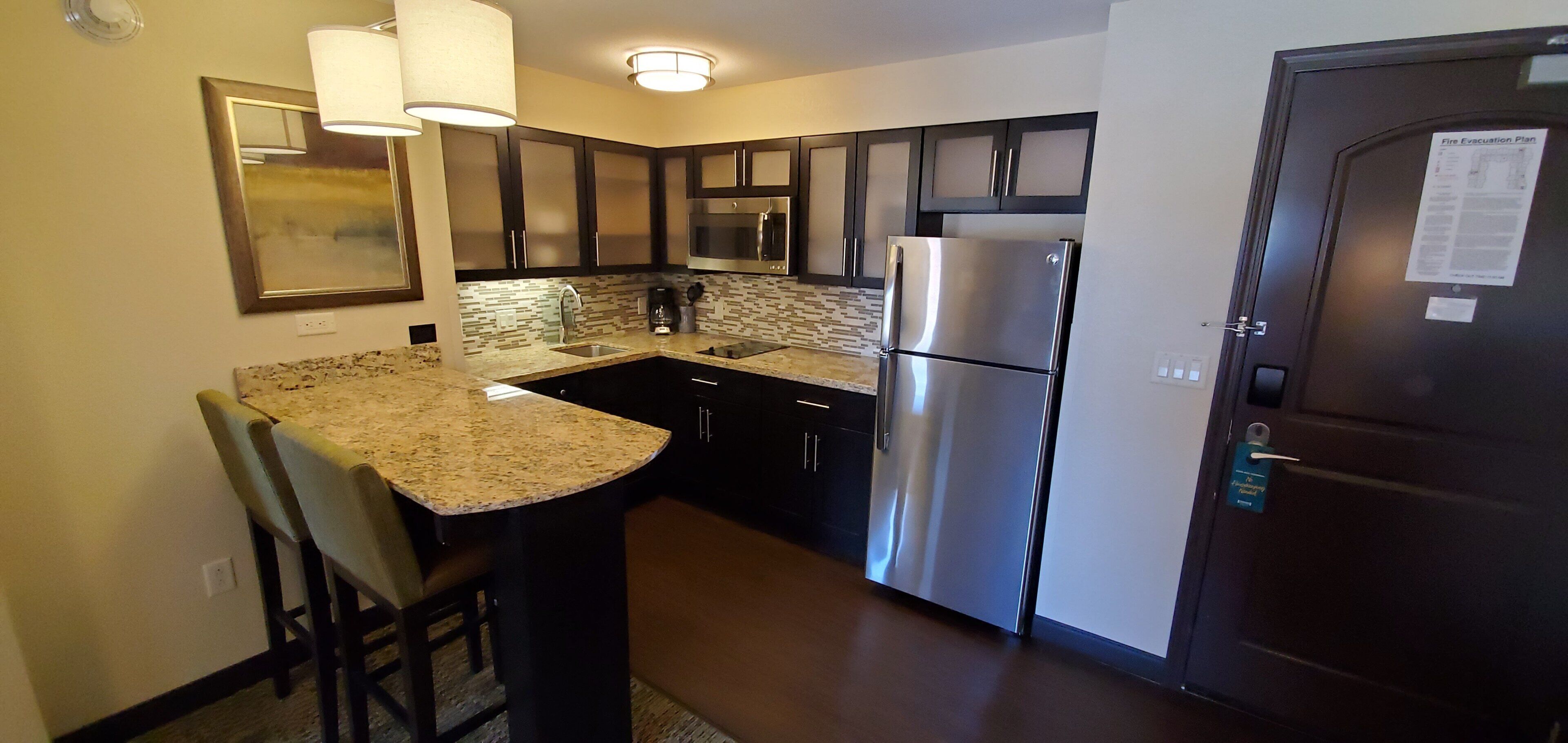 A compact kitchen with a refrigerator, microwave, and a coffee maker.