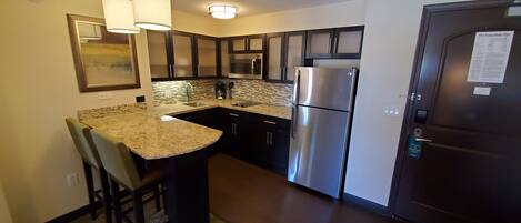 A compact kitchen with a refrigerator, microwave, and a coffee maker.