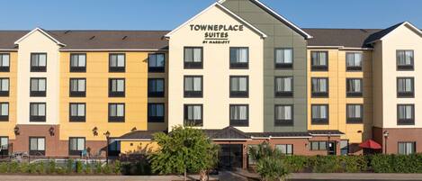 A hotel with multiple floors, a prominent sign reading "Towneplace Suites by Marriott," and a landscaped entrance area.
