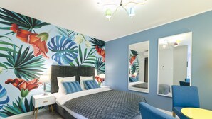 A modern bedroom with a large bed, a nightstand, a chair, a small table, and a mirror. - Aparthotel Apartments Wrocław (Wroclaw)