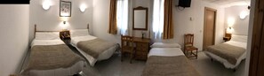 A room with two beds, a wooden dresser, a chair, and a mirror. - Hostal Alcázar (Toledo)