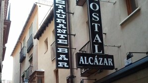 A building with signs for a restaurant and a hostel. - Hostal Alcázar (Toledo)
