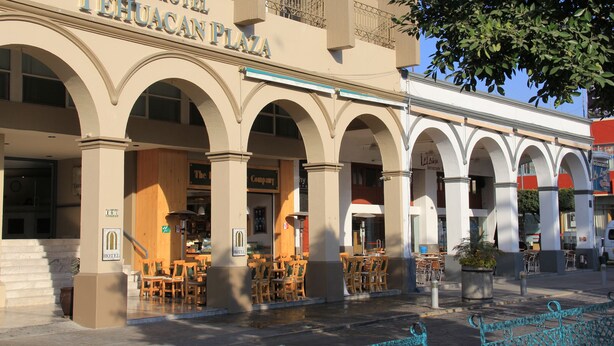 A hotel with a prominent arched entrance and outdoor seating area. - Hotel Tehuacan Plaza (Tehuacán)