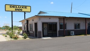 Rakennuksessa on kyltti, jossa lukee ”Deluxe Inn”, ja sen katto on sininen.