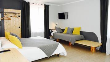 A modern hotel room with two beds, a wooden bench, a TV, and a wooden wardrobe.