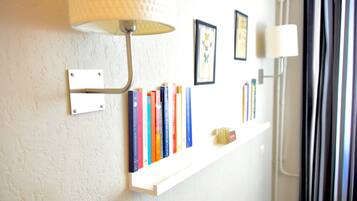 Una mensola a muro con libri e una lampada.